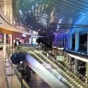 Outside of a shopping mall with an escalator in view