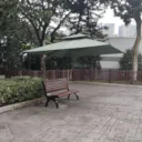 A bench under a green canopy